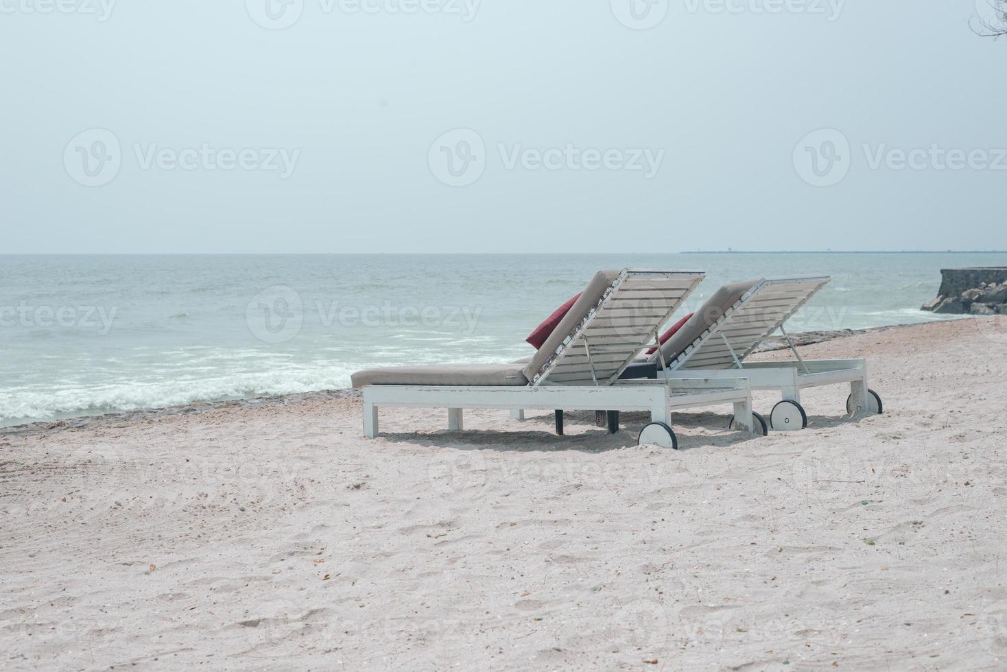 Two sun-beds on tropical beach - vacation time photo