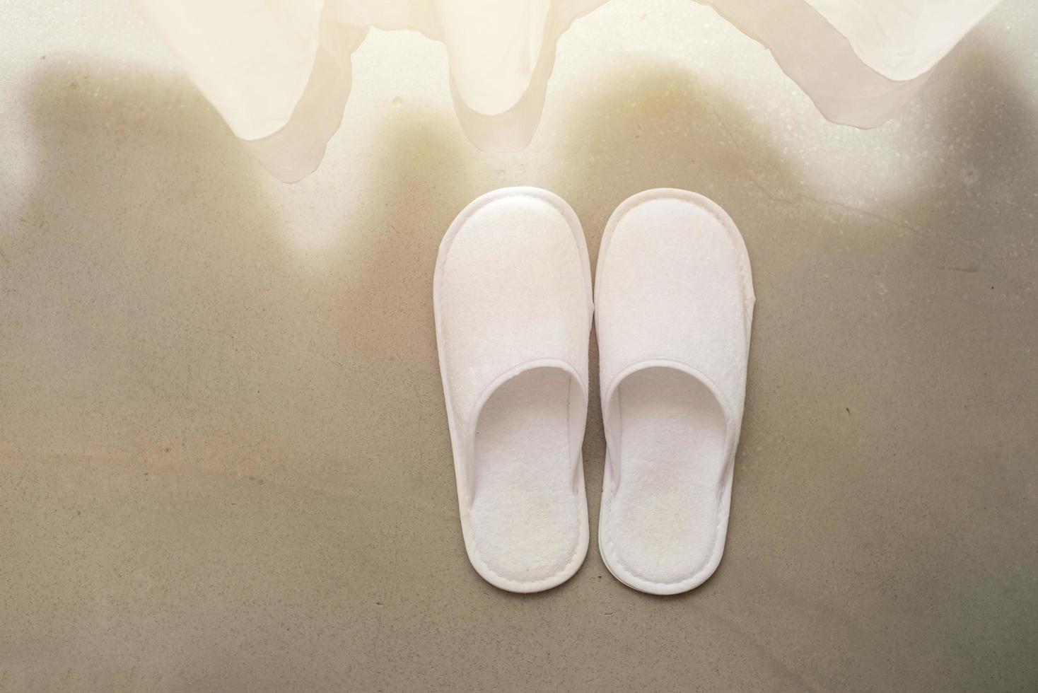 White slippers by white sheer curtains and soft sunlight, vacation concept photo