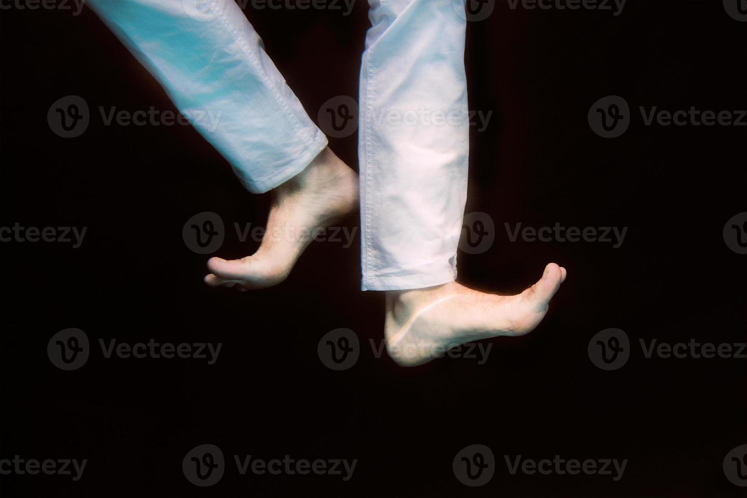 dancing legs underwater on black background in the swimming pool photo