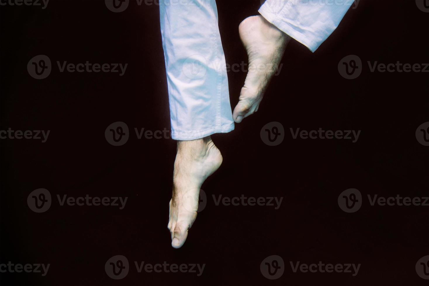 dancing legs underwater on black background in the swimming pool photo