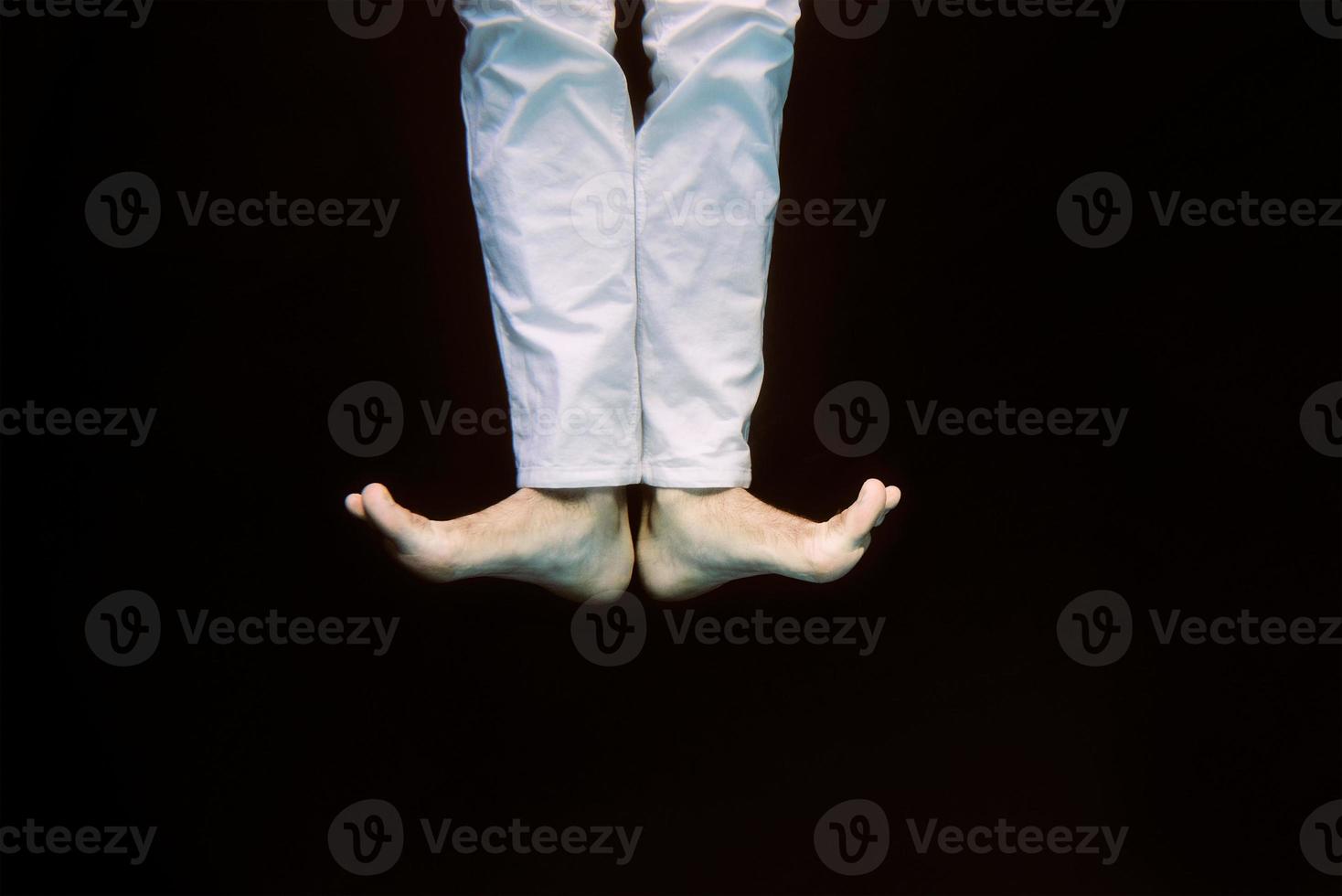 dancing legs underwater on black background in the swimming pool photo