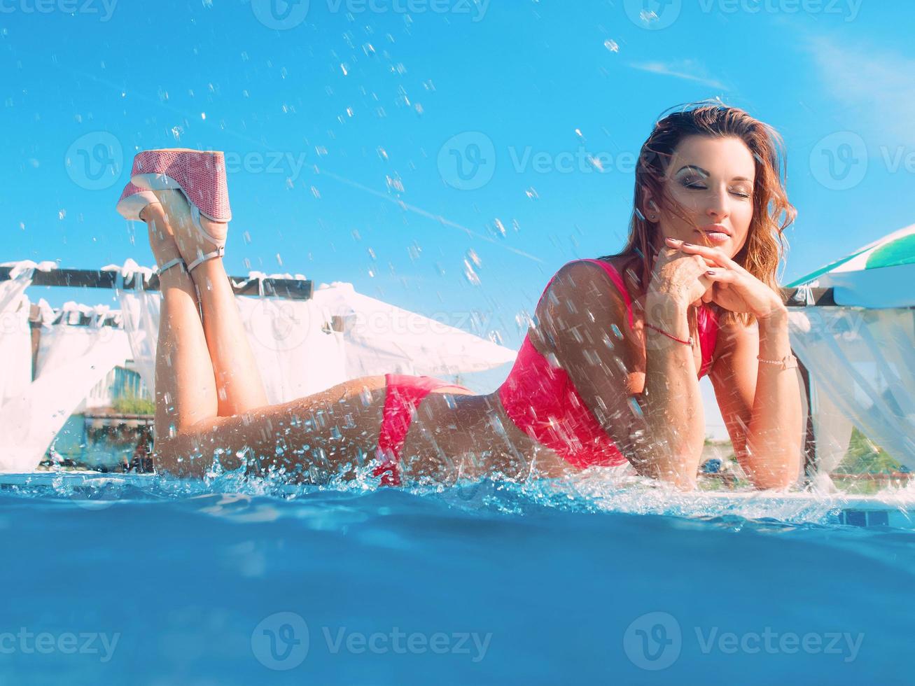 young beautiful woman having summer fun in the swimming pool photo