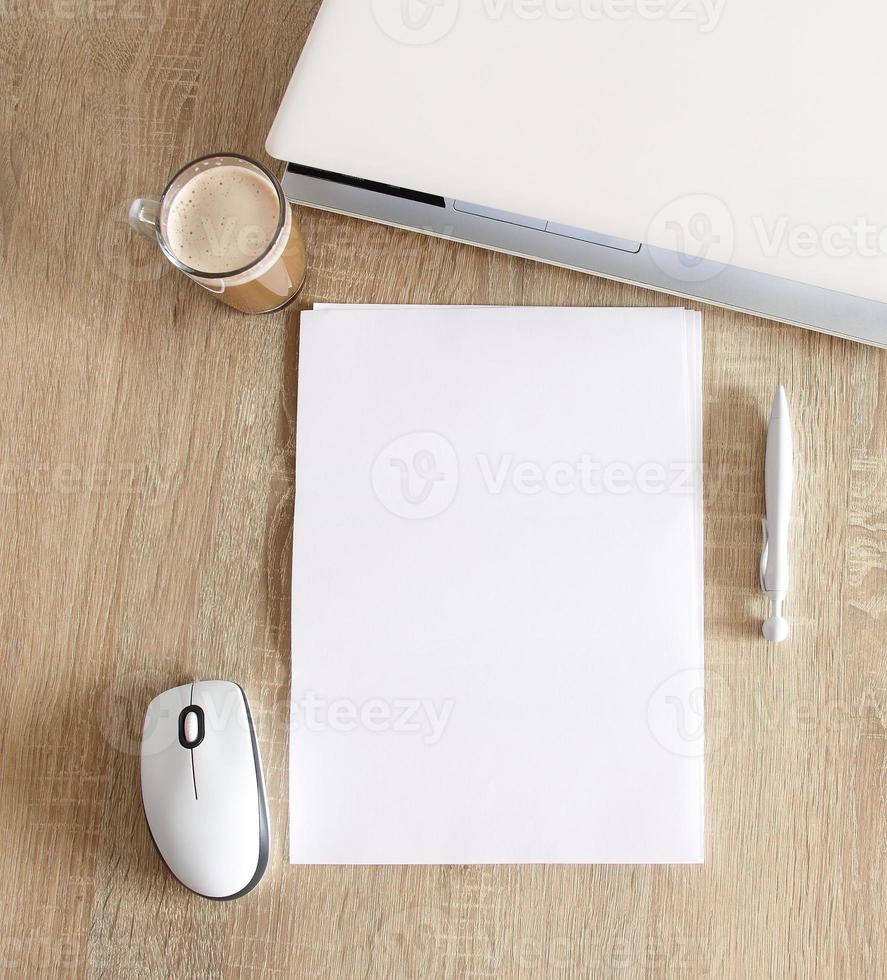 A4 blank white pperon table with laptop and mouse photo