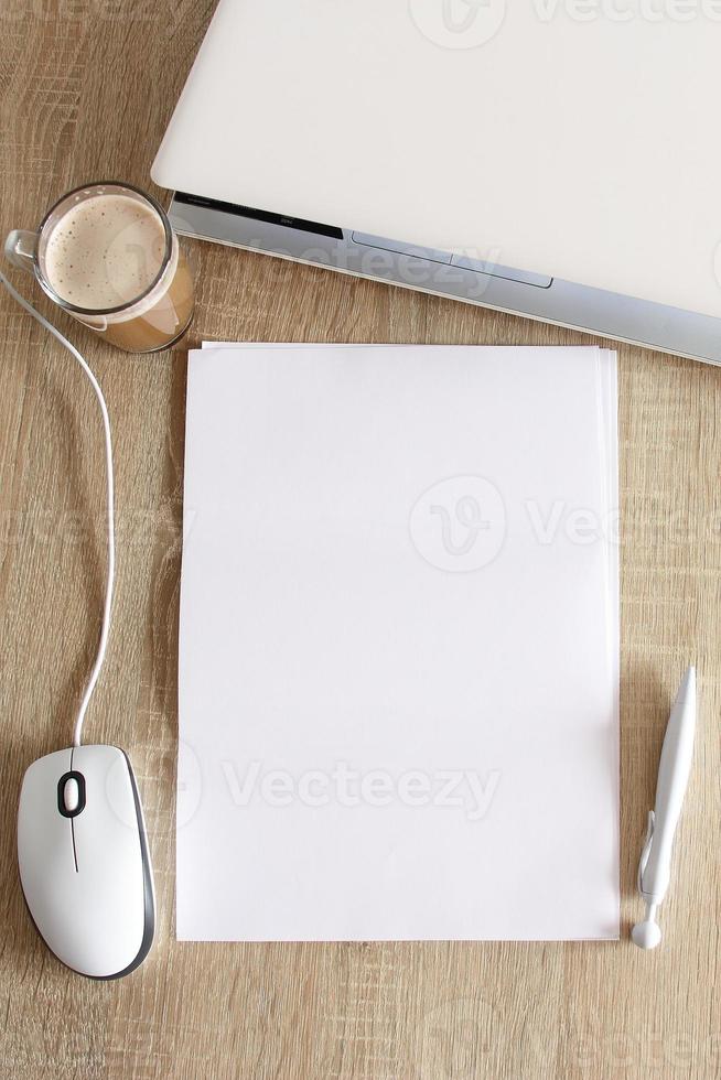 A4 blank white pperon table with laptop and mouse photo