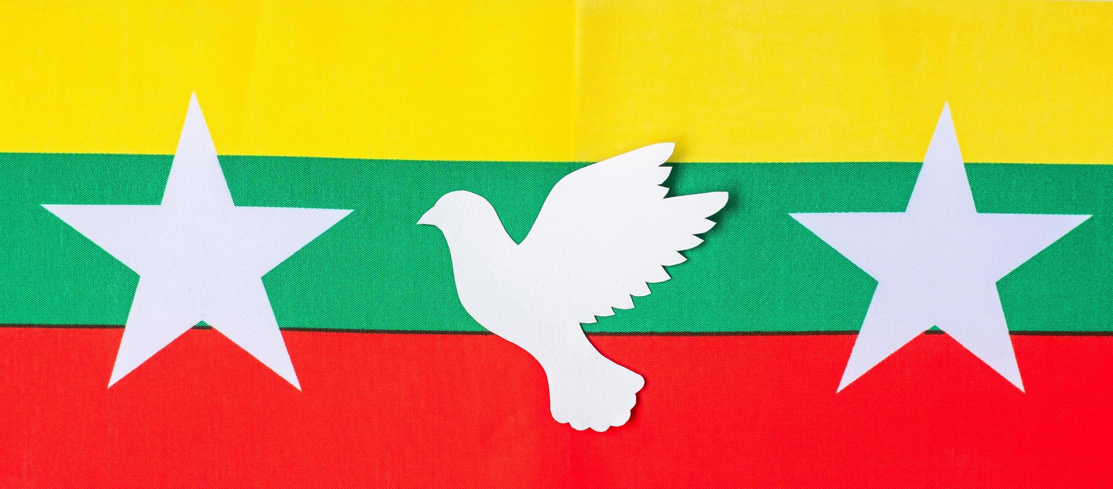 Support for Myanmar people, peace dove with flag of Myanmar. Freedom, stop war, dictatorship and democracy concepts photo