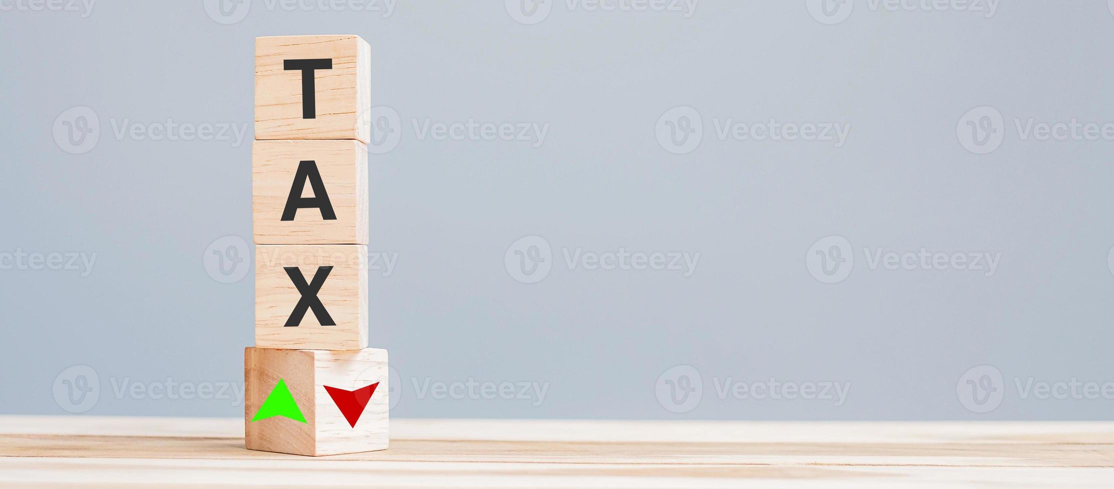 bloque de cubo de madera con texto de impuestos para el icono de símbolo de flecha hacia arriba y hacia abajo. concepto financiero, de gestión, económico, comercial y de tiempo para impuestos foto