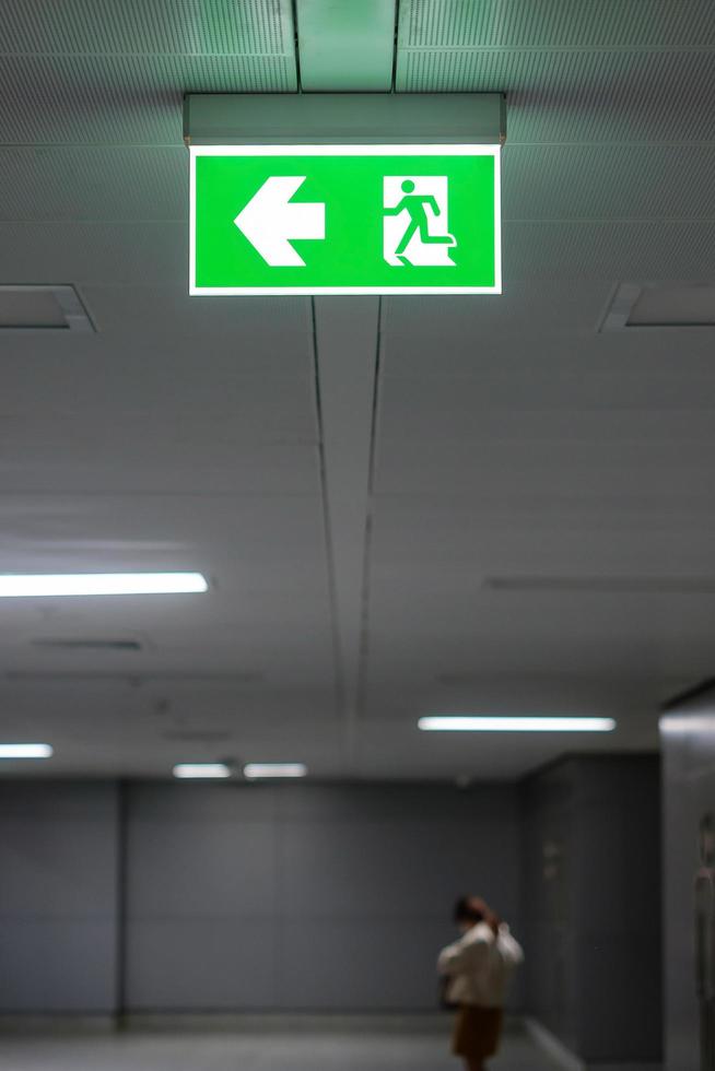 Fire Emergency exit sign on the wall inside building at subway train station. Safety concept photo