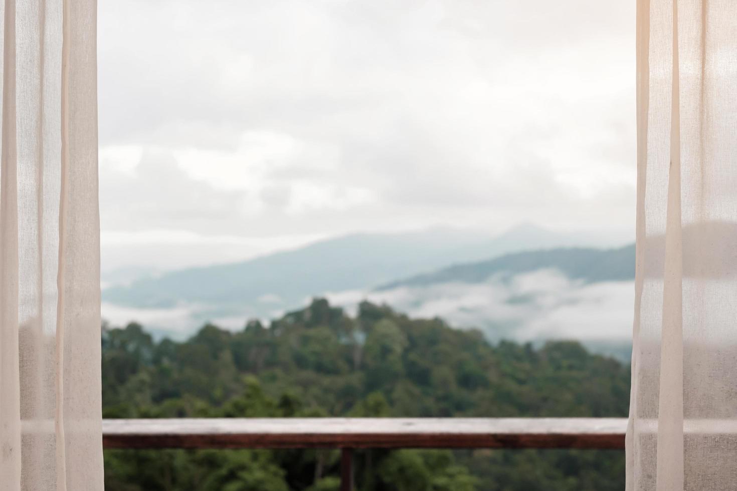 Beautiful mountain view with balcony and window curtain at countryside home or homestay in the morning photo