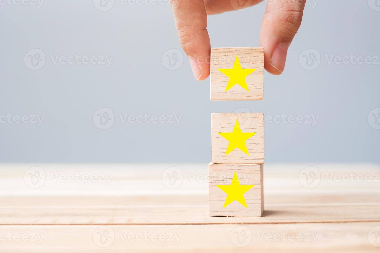 Hand holding wooden blocks with the star symbol. Customer reviews, feedback, rating, ranking and service concept. photo