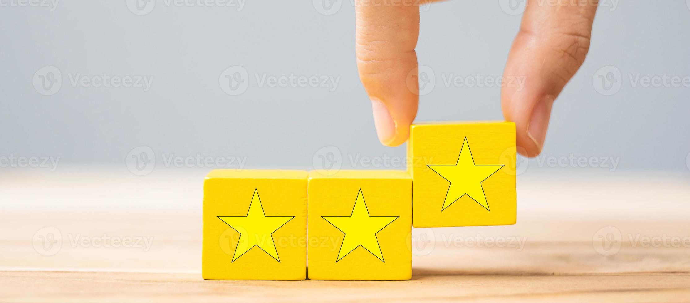 Hand holding wooden blocks with the star symbol. Customer reviews, feedback, rating, ranking and service concept. photo