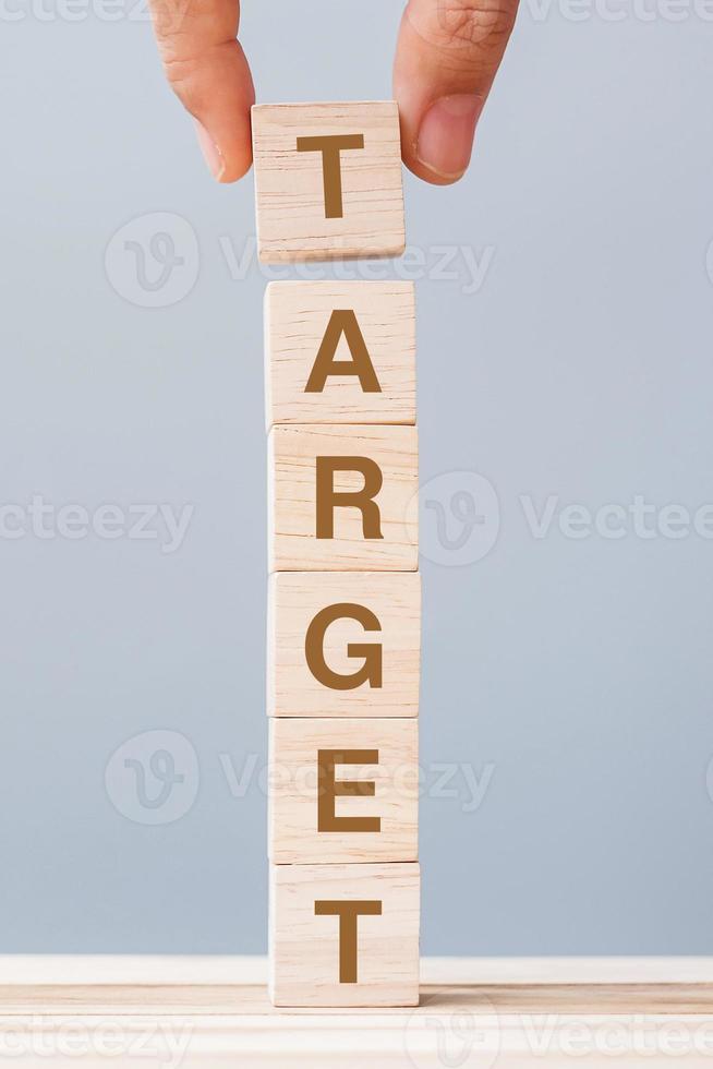 Business man hand holding wooden cube block with TARGET business word. goal, aim, Mission, action and plan concept photo