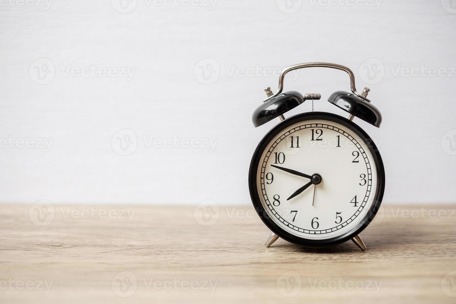 Vintage alarm clock on wooden table background and copy space for text. Activity, daily routine, morning, workout and Work life balance concept photo