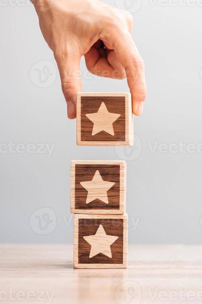 Man hand holding Star block. Customer choose rating for user reviews. Service rating, ranking, customer review, satisfaction, evaluation and feedback concept photo