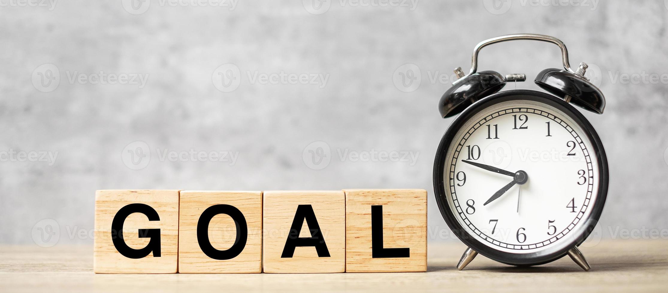 Vintage alarm clock with GOAL block on table. Activity, daily routine, morning, workout and Work life balance concept photo