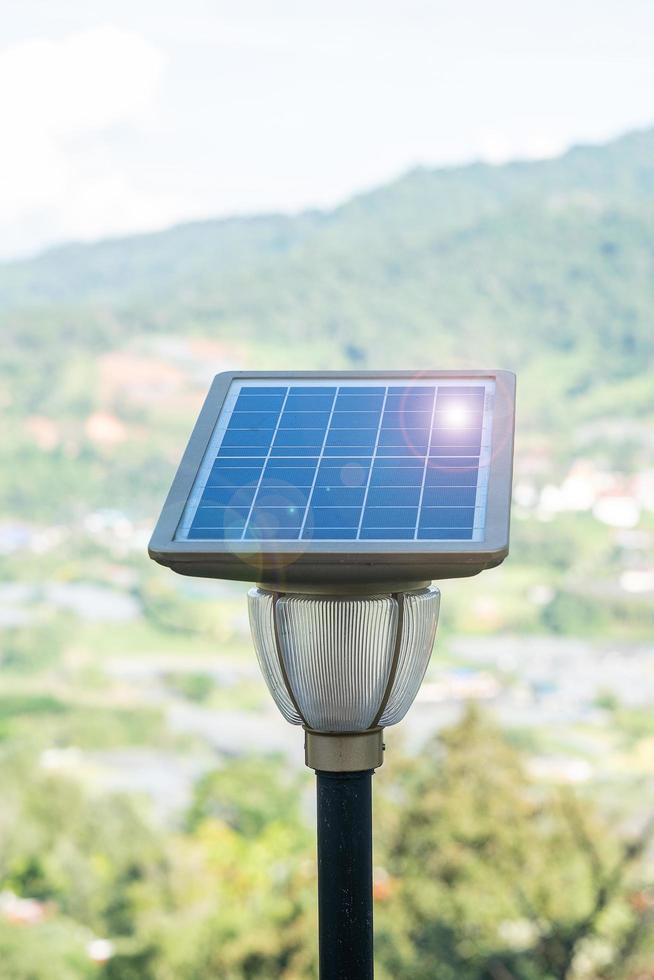 pequeños paneles solares fotovoltaicos con lámpara de luz en el bosque, sistemas de generación de energía eléctrica. concepto de energía alternativa, renovable y recursos sostenibles foto