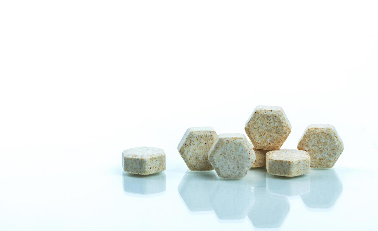 Macro shot detail of brown hexagon medical lozenges with Brazilian green propolis extract for relief cough, sore throat and throat irritation on white background with copy space. Lozenges tablets photo