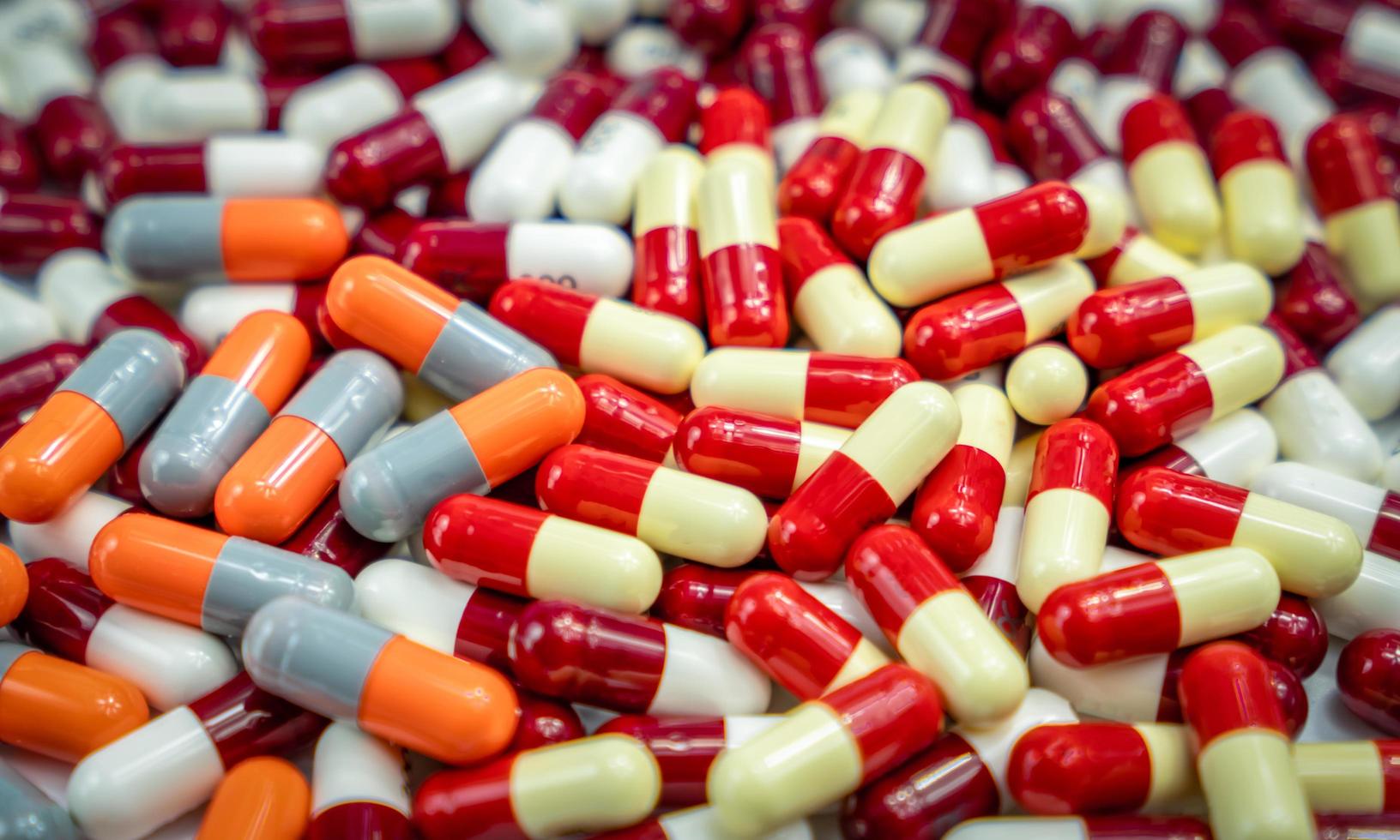 Pile of antibiotic capsule pills. Pharmaceutical industry. Drug production. Pharmacy drugstore background. Global healthcare. Drug interaction. Antibiotic drug resistance. Antimicrobial capsule pills. photo