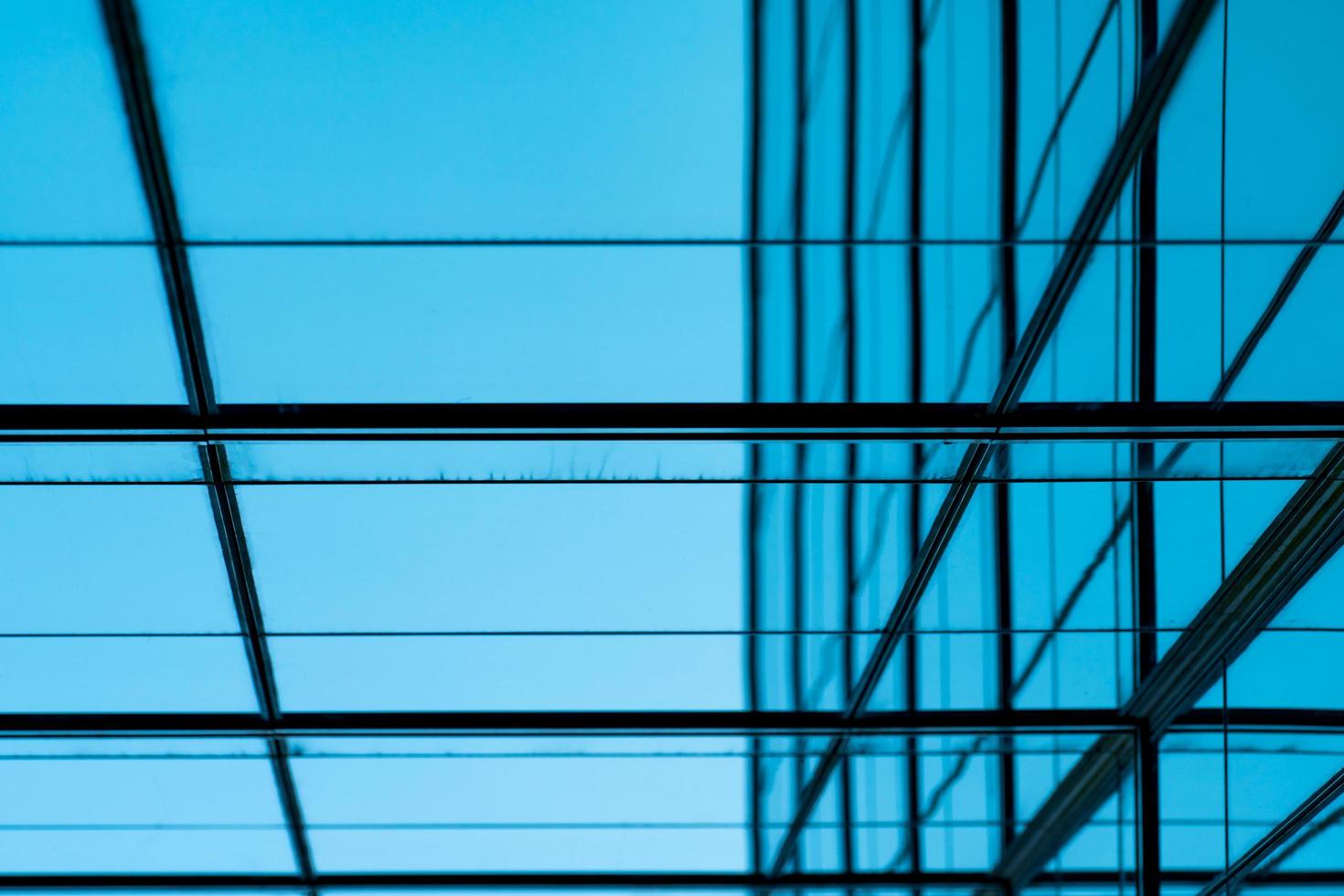 Perspective view of modern futuristic glass building abstract background. Exterior of office glass building architecture. Reflection in transparent glass of business building. Company glass window. photo