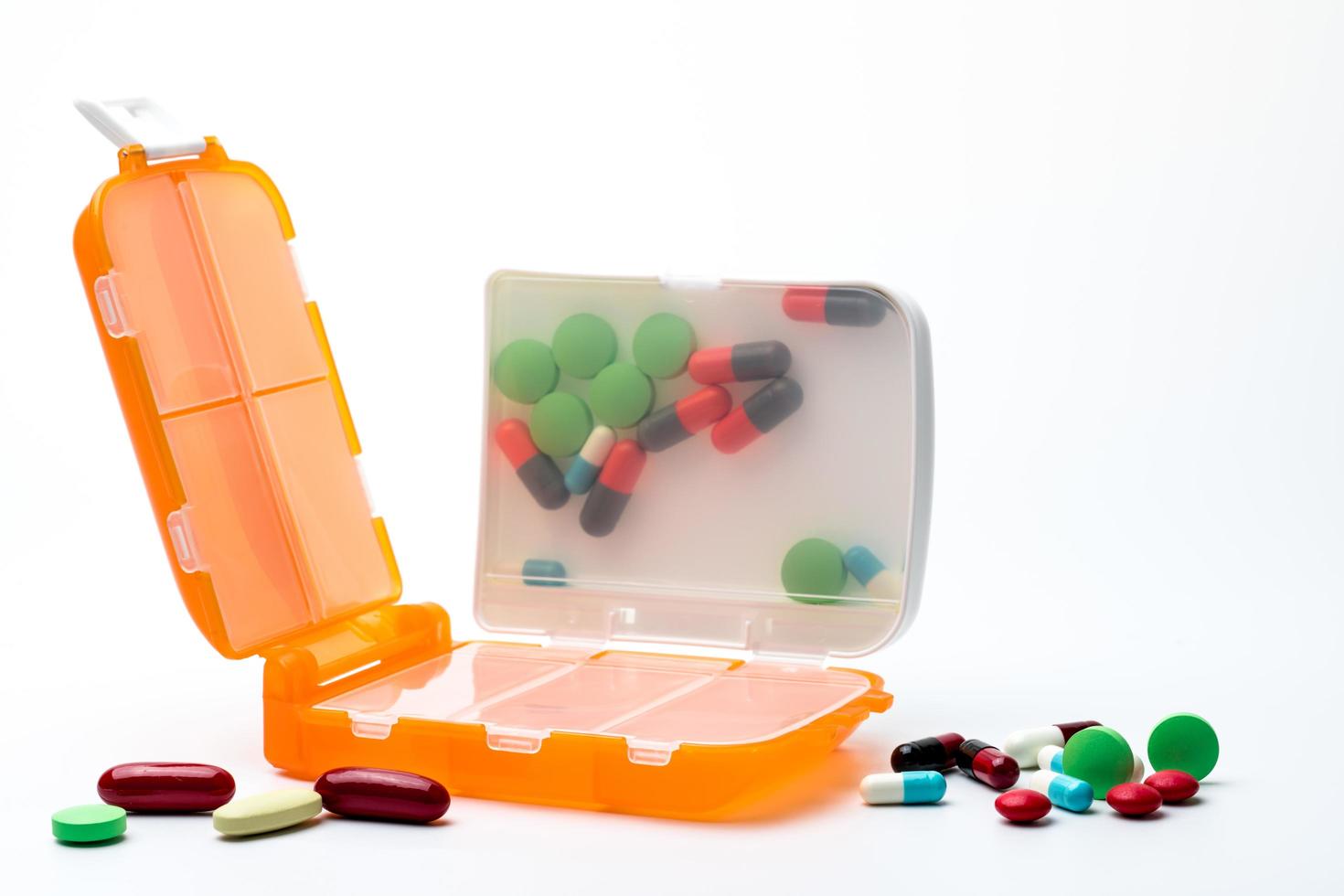 Orange pills box with tablets and capsule pills isolated on white background with copy space. Prepare medicine before work or travel abroad concept. photo