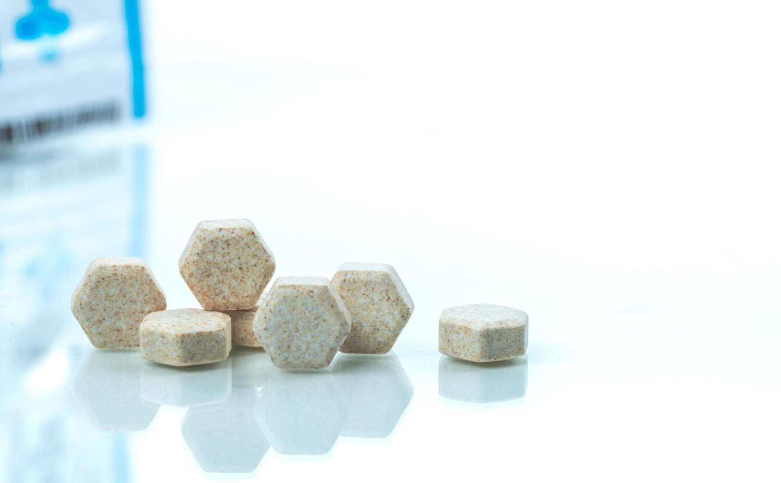 Macro shot detail of brown hexagon medical lozenges with Brazilian green propolis extract for relief cough, sore throat and throat irritation on white background with copy space. Lozenges tablets photo