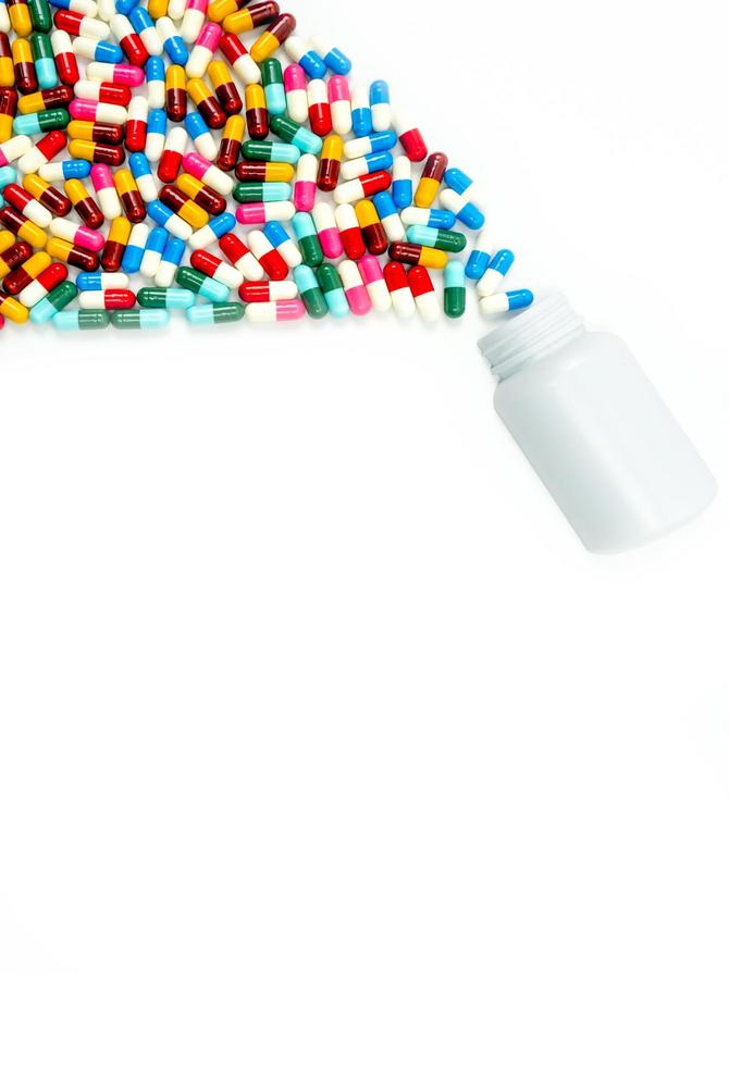 Antibiotic capsules spilling out of pill bottle on white background with copy space, just add your own text. Drug resistance concept. Antibiotics drug use with reasonable and global healthcare concept photo