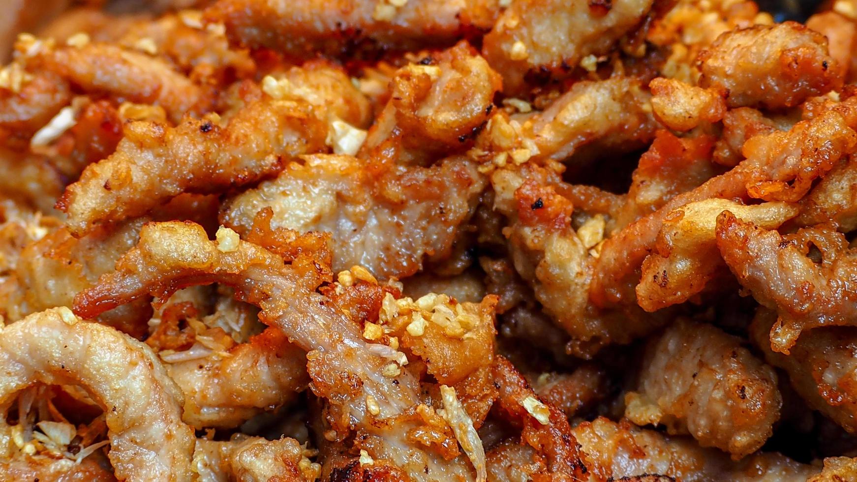 Fried pork with garlic fried. Asian food. Thai cuisine. Closeup dried chopped pork fried. Breakfast or lunch appetizer food in Thailand. Street food. Protein and fat source. Delicious recipes. photo
