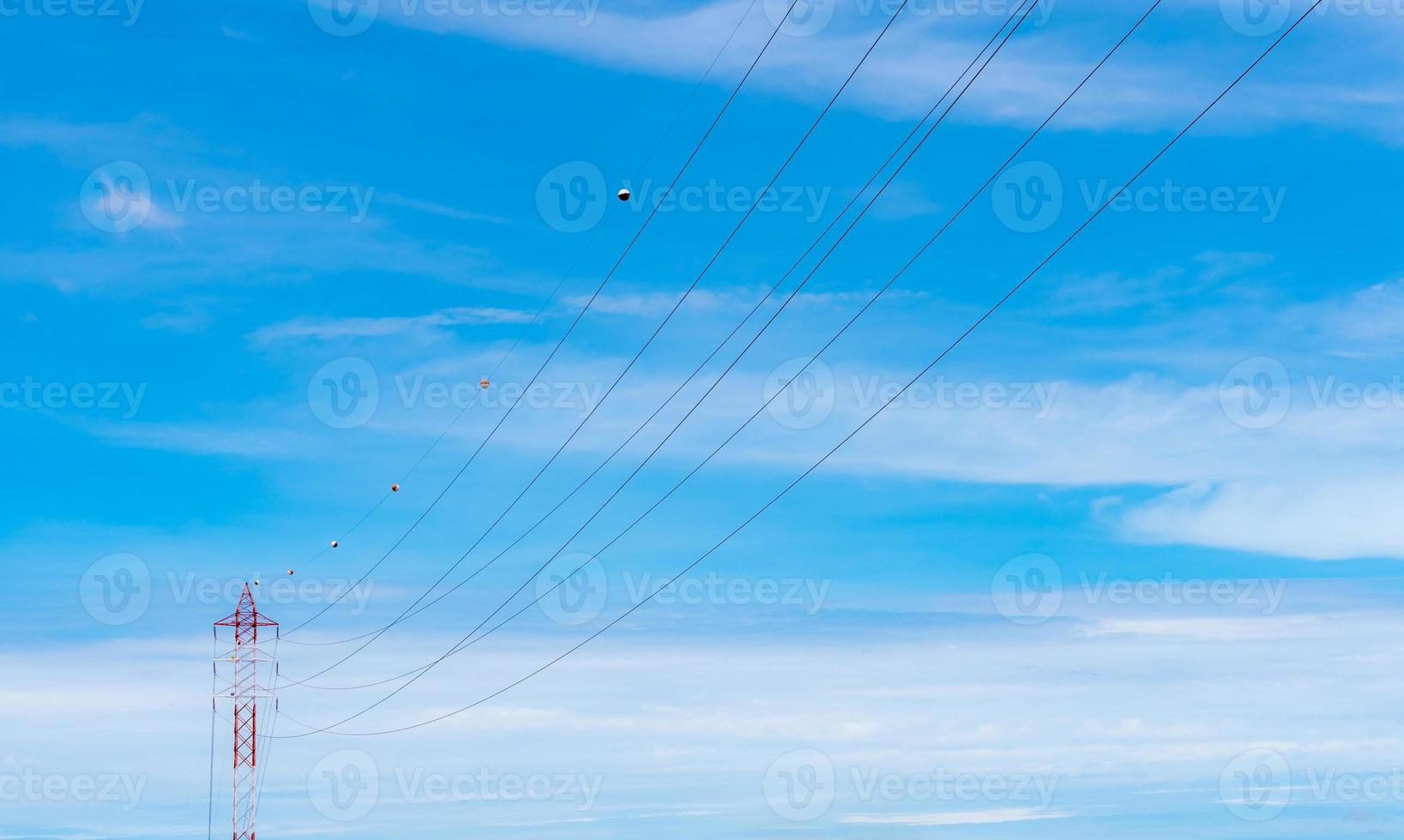 High voltage power lines against blue sky. High voltage electric transmission tower. Electricity pylon and electric power transmission lines. High Voltage tower provide power supply. Power and energy. photo
