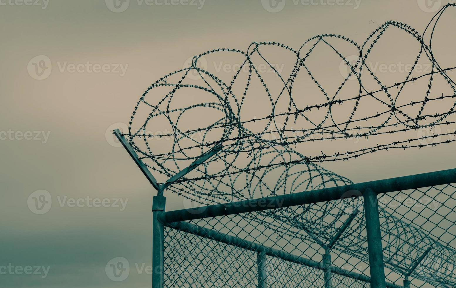 Prison security fence. Barbed wire security fence. Razor wire jail fence. Barrier border. Boundary security wall. Prison for arrest criminals or terrorists. Private area. Military zone concept. photo