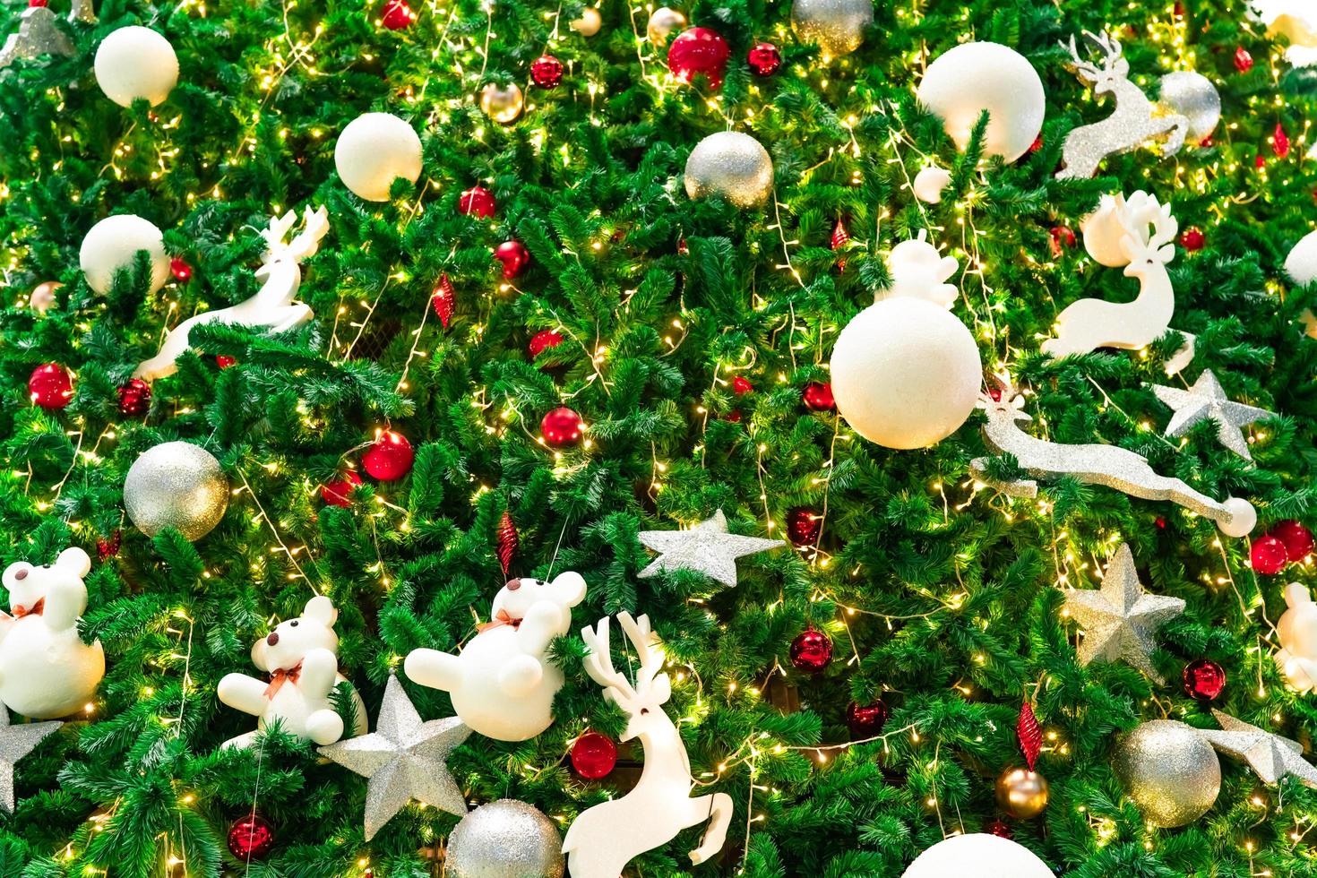 Close up Christmas tree decoration with red, gold, silver, and white balls, silver star and white reindeer. Xmas background. Christmas and Happy New Year background. Colorful ball on Christmas tree. photo