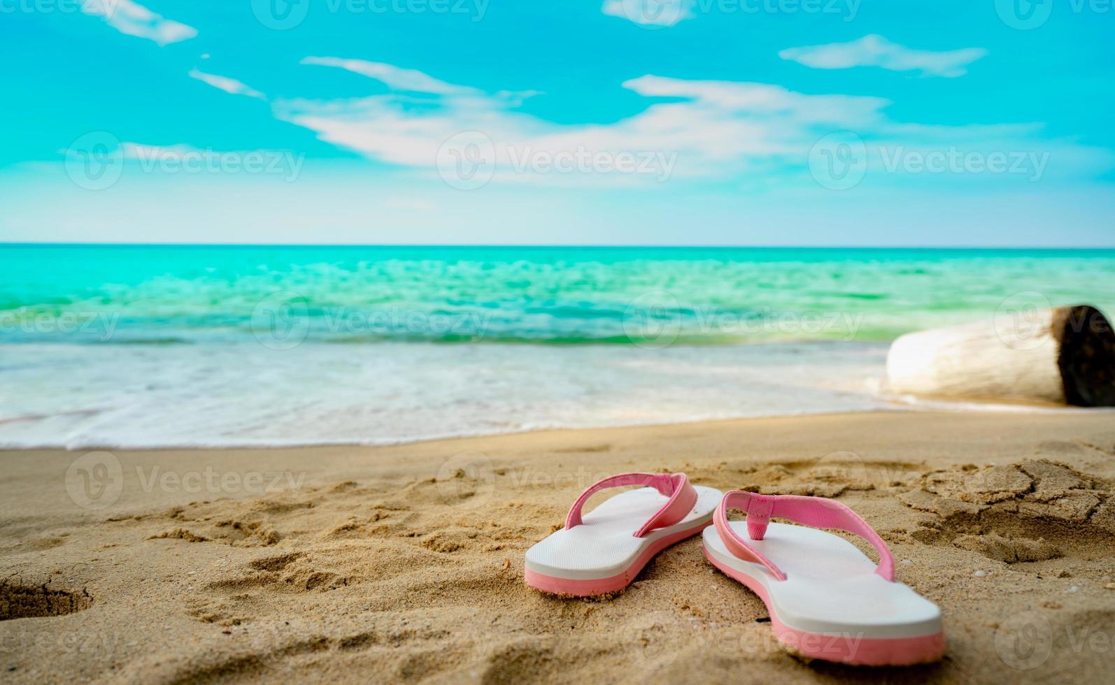 Pink and white sandals on sand beach. Casual style flip-flop were removed at seaside. Summer vacation on tropical beach. Fun holiday travel on sandy beach. Summertime. Summer vibes. Relaxing time. photo