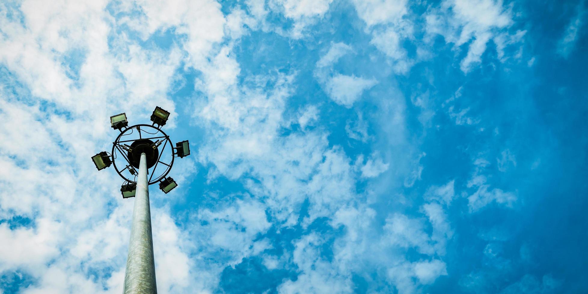 Sport lights of the stadium with pole on beautiful blue sky and white cumulus clouds with copy space for text. photo