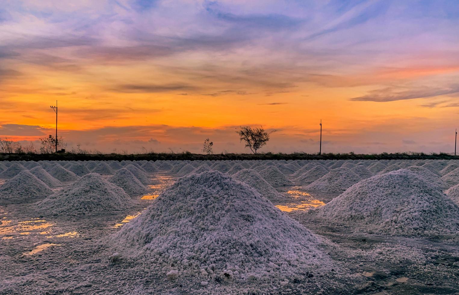 Salt farm in the morning with sunrise sky. Organic sea salt. Evaporation and crystallization of sea water. Raw material of salt industrial. Sodium Chloride. Solar evaporation system. Iodine salt. photo