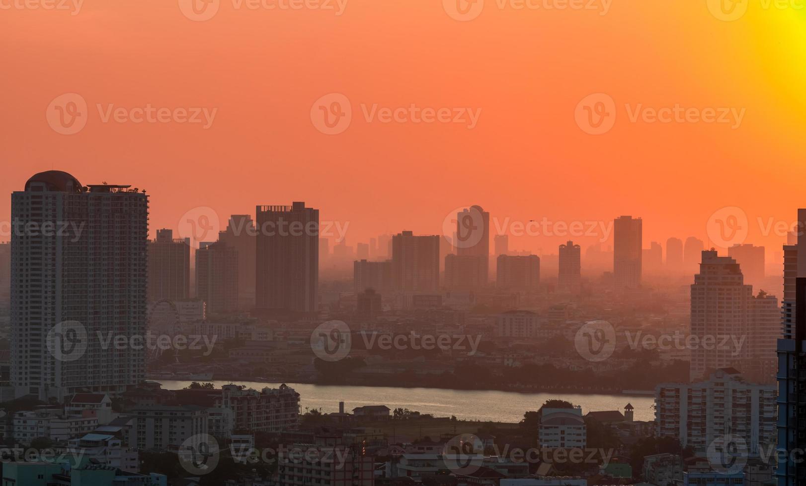 Cityscape with polluted air. Air pollution. Smog and fine dust covered city in the morning with orange sky. Environmental problem in big city. Toxic fine dust. Unhealthy air. Urban unhealthy living. photo