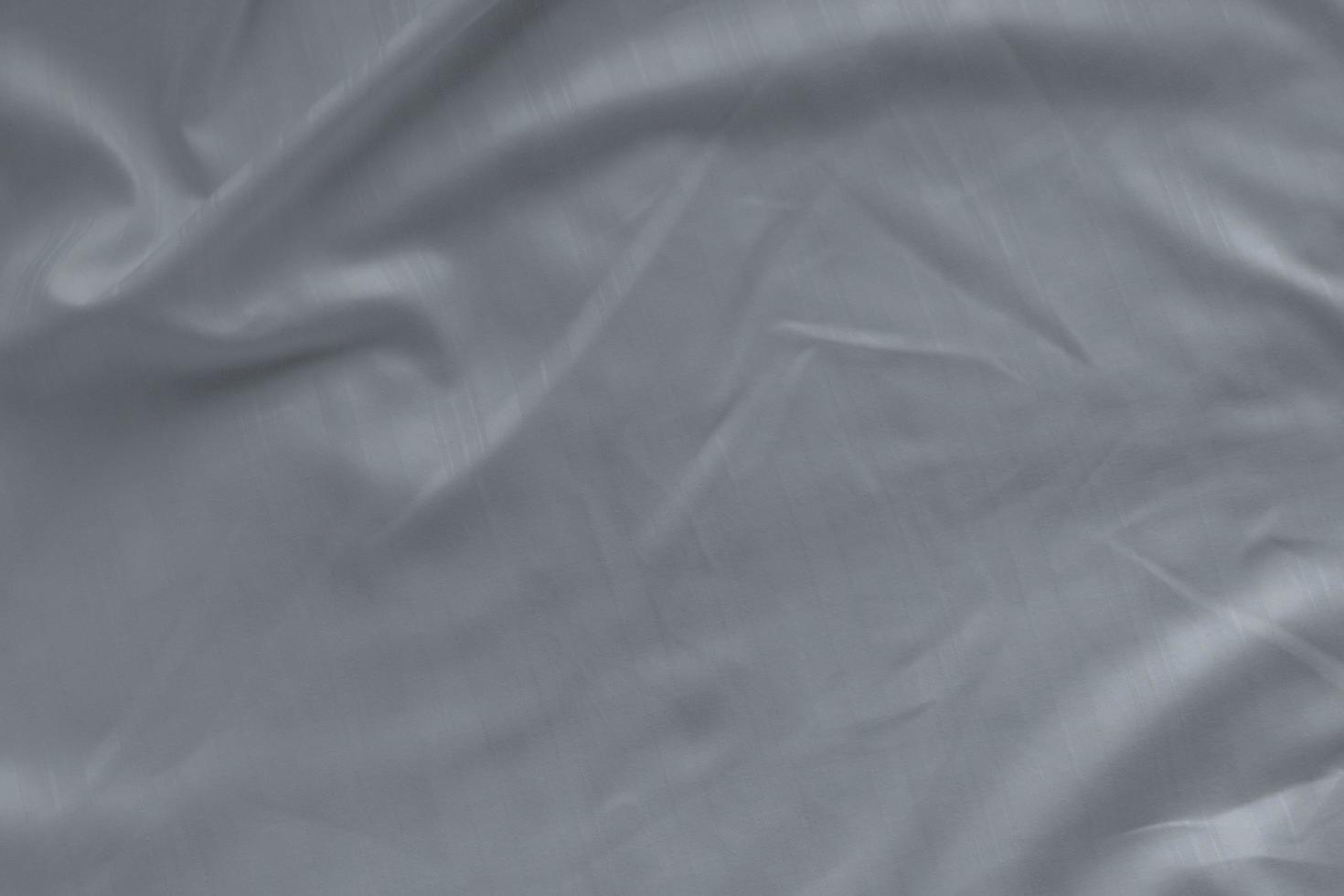 White linen bed sheet texture in hotel bedroom. Closeup detail of messy white bed sheet. Comfortable bed with house dust mite proof sheets. Bedding household concept. Allergen proof microfiber fabric. photo