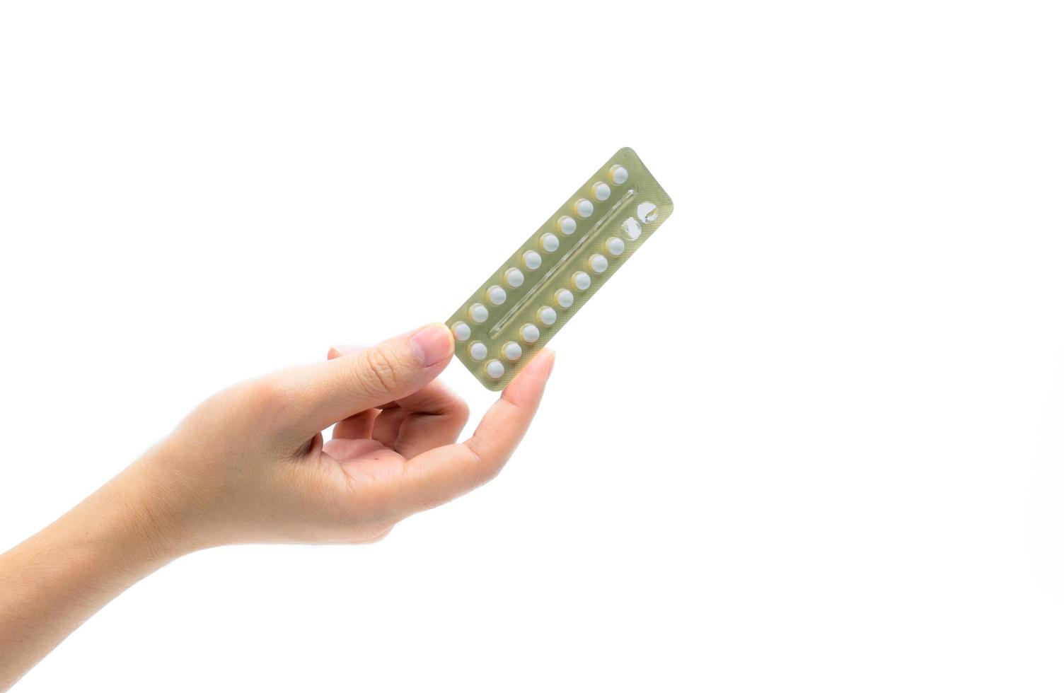 mano de mujer tomando pastillas anticonceptivas. mujer adulta asiática sosteniendo un paquete de píldoras anticonceptivas aisladas en fondo blanco con camino de recorte. elegir la planificación familiar con el concepto de píldoras anticonceptivas foto