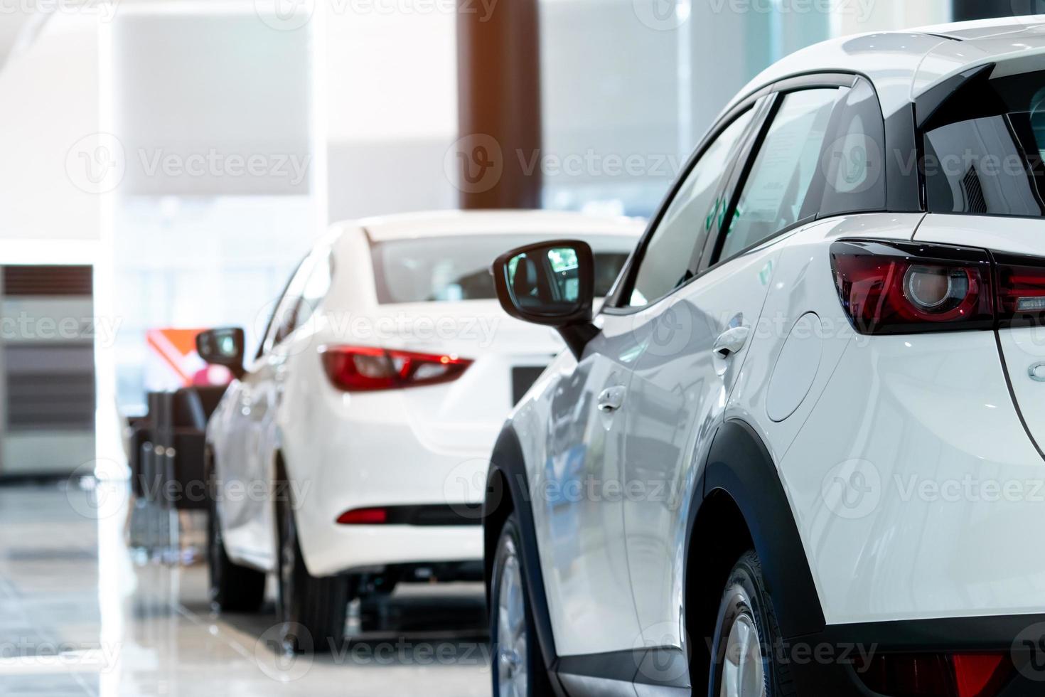 Rearview car parked in luxury showroom. Car dealership office. New car parked in modern showroom. Car for sale and rent business concept. Automobile leasing and insurance concept. Electric automobile. photo