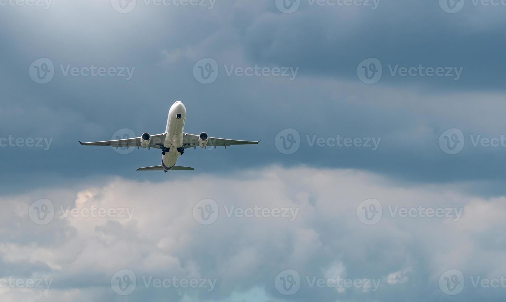 Commercial airline flying on blue sky and white fluffy clouds. Under view of airplane flying. Passenger plane after take off or going to landing flight. Vacation travel abroad. Air transportation. photo