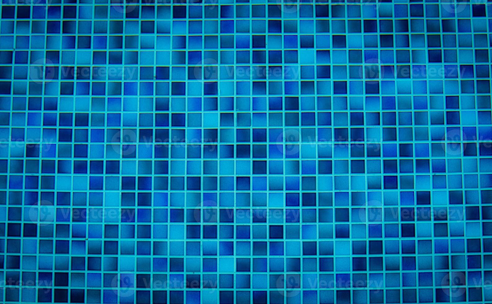 Blue tile pattern of swimming pool tiles. Pool tiles texture background. Clean water with swimming pool mosaic tiles floor. Modern pattern of tiny square pool mosaic floor of bathroom or shower room. photo