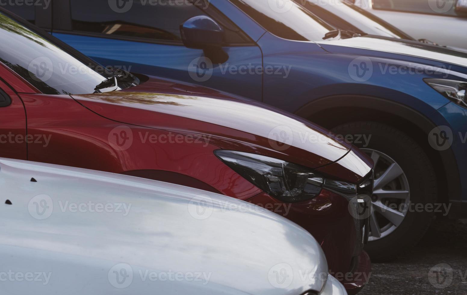 Car parked at parking lot of the airport for rental. Side view of red, blue SUV car. Used luxury car for sale and rental service. Automobile parking space. Car dealership concept. Automotive industy. photo