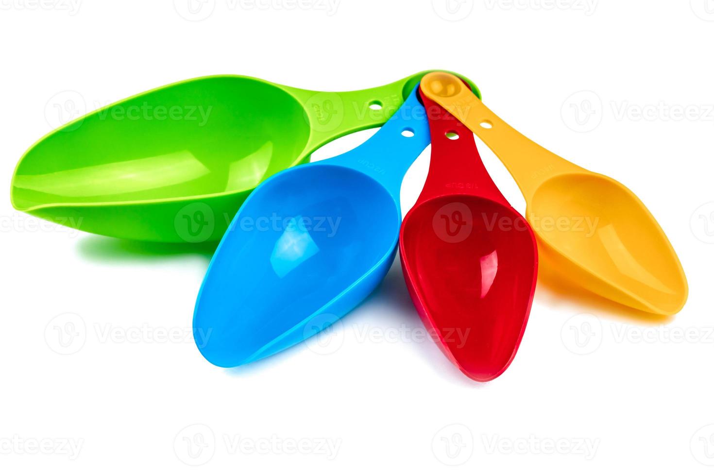Set of colorful plastic measuring spoon isolated on white background with shadow. Green, blue, red, and orange plastic measuring spoon. Kids toy photo