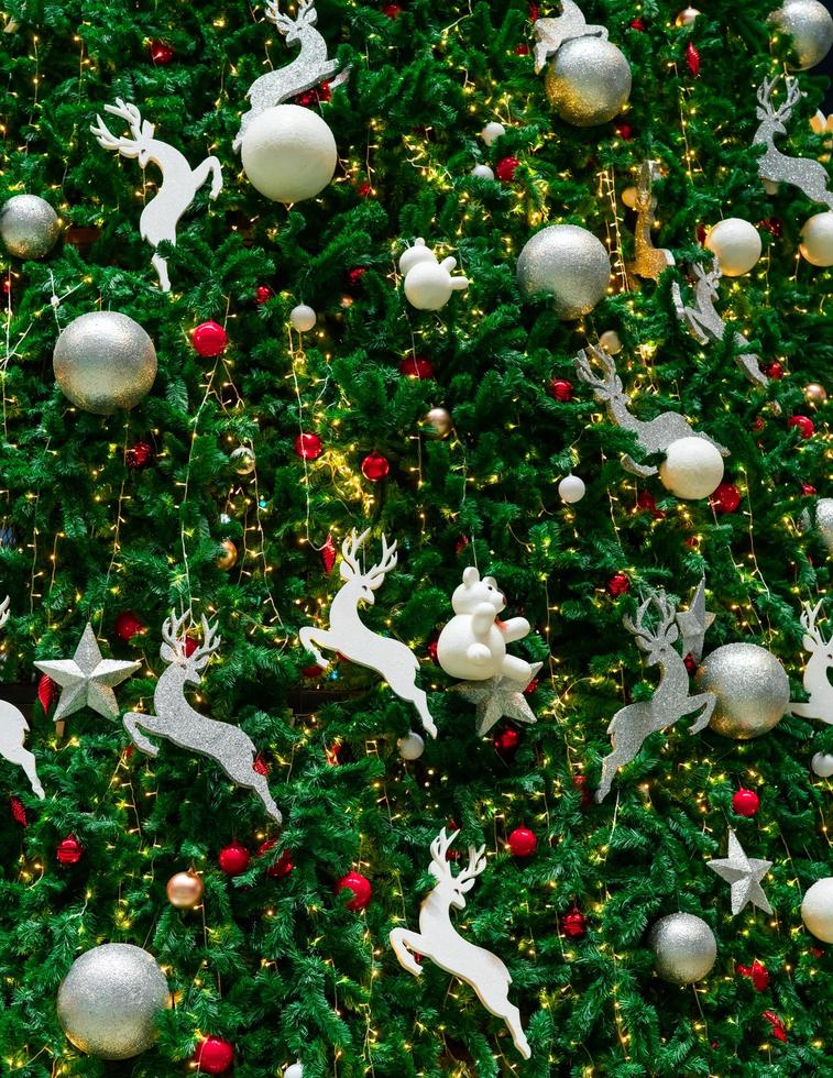 Close up Christmas tree decoration with red, gold, silver, and white balls, silver star and white reindeer. Xmas background. Christmas and Happy New Year background. Colorful ball on Christmas tree. photo