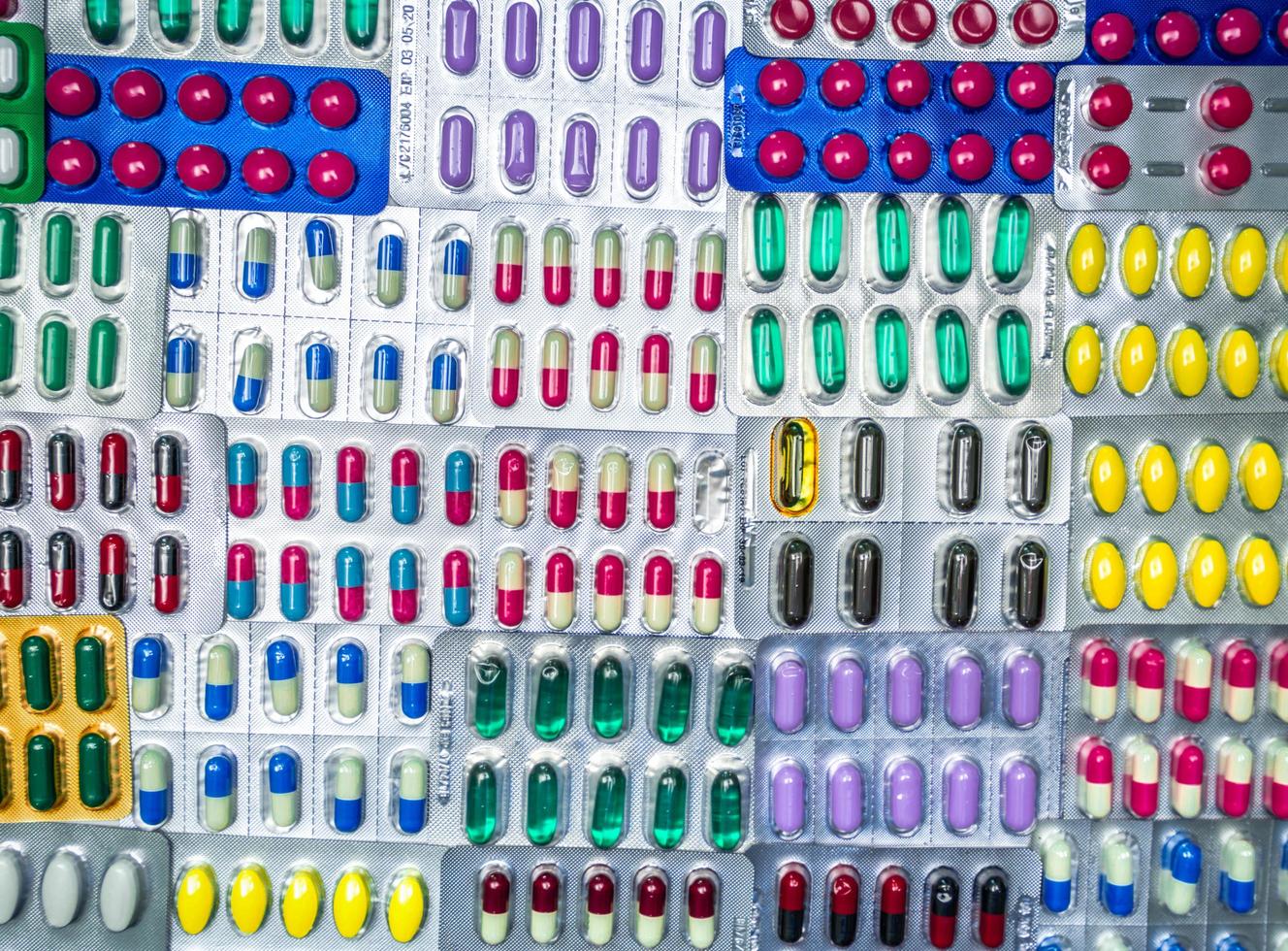 la vista superior de las tabletas de colores y las píldoras de cápsulas en envases de blíster se organizan con un patrón hermoso. concepto de industria farmacéutica. fondo de píldoras de fotograma completo. productos farmacéuticos globales foto