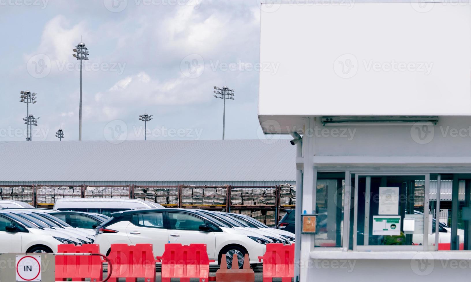 stock de autos nuevos en el estacionamiento de la fábrica de automóviles. fabricación de producción de automóviles. stock de autos en espera de venta. Estacionamiento de fábrica de autos y caseta de vigilancia para seguridad. industria automotriz. negocio del automóvil. foto