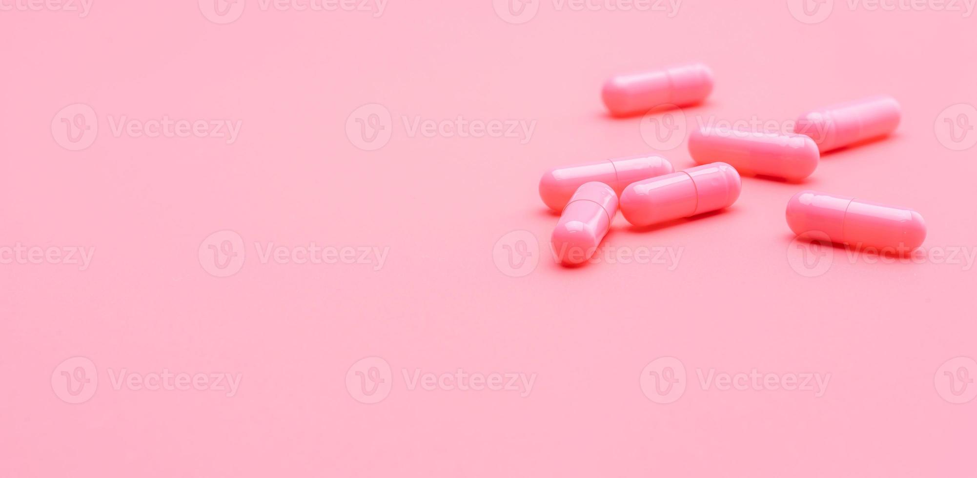 píldora de cápsulas de color rosa sobre fondo de color rosa. vitaminas y suplementos. farmacia en línea. pancarta de la tienda de farmacia. industria farmacéutica. concepto de seguro de salud de la mujer. Pastillas para el amor y la vida feliz. foto