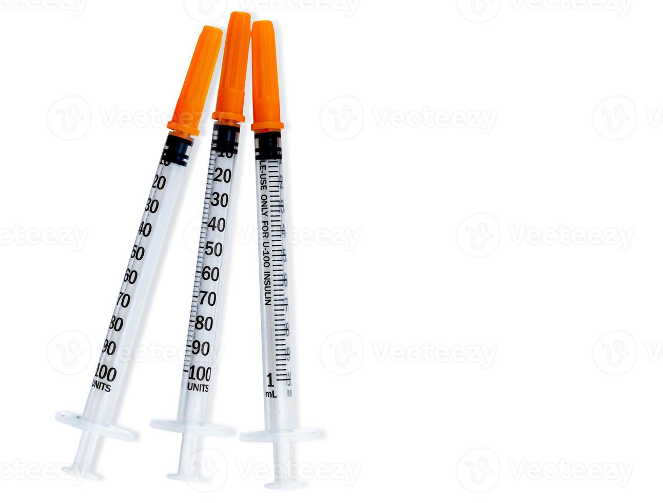 Plastic insulin syringes for diabetes. Needle for addict. Three insulin syringes with orange cover isolated on white background. Injection medicine. Medical equipment for diabetic. Vaccination concept photo