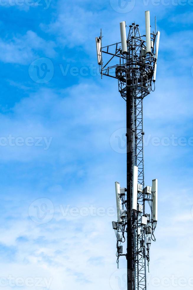 Telecommunication tower with blue sky and white clouds background. Antenna on blue sky. Radio and satellite pole. Communication technology. Telecommunication industry. Mobile or telecom 4g network. photo