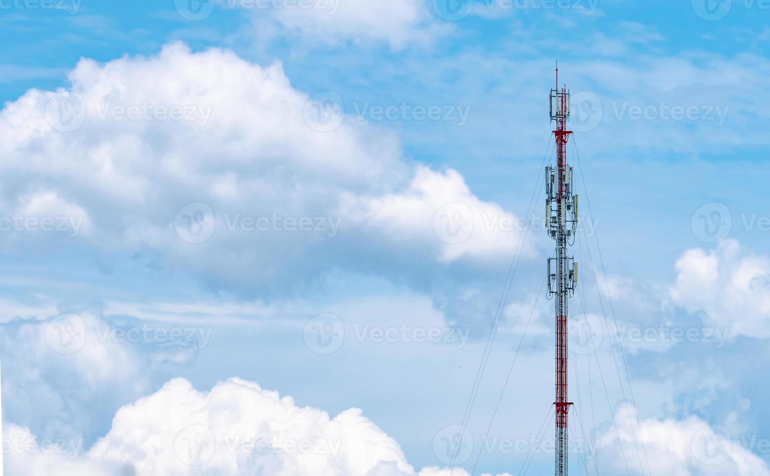 Telecommunication tower with blue sky and white clouds background. Antenna on blue sky. Radio and satellite pole. Communication technology. Telecommunication industry. Mobile or telecom 4g network. photo