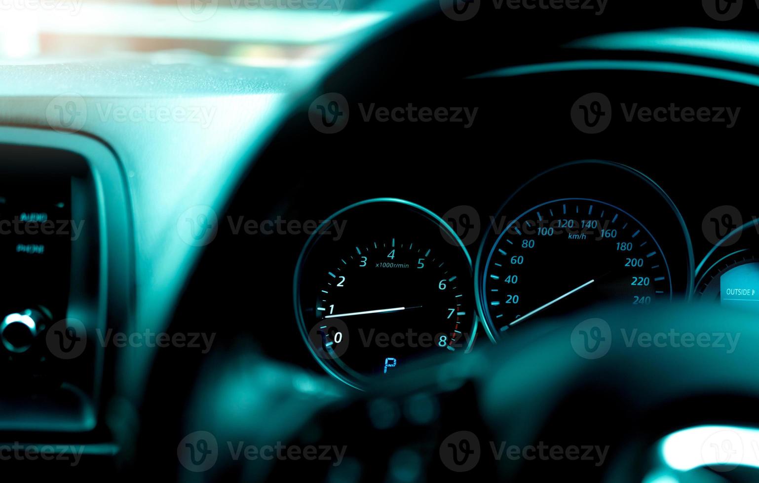 vista interior del salpicadero del coche. panel de instrumentos del coche con tacómetro y velocímetro. vista desde el volante hasta el indicador de rpm y el medidor de velocidad. indicador de motor de coche. tablero de instrumentos de primer plano con luz automática. foto