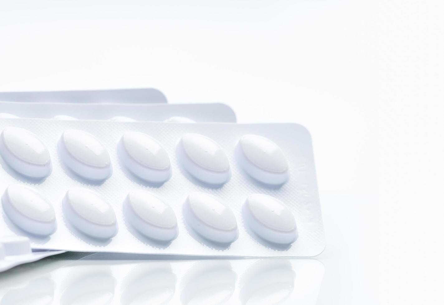 Macro shot of pills in white blister pack for light resistance packaging isolated on white background. Medicine for treatment dyslipidemia. Lipid lowering tablets pills. Statins Hyperlipidemia. photo