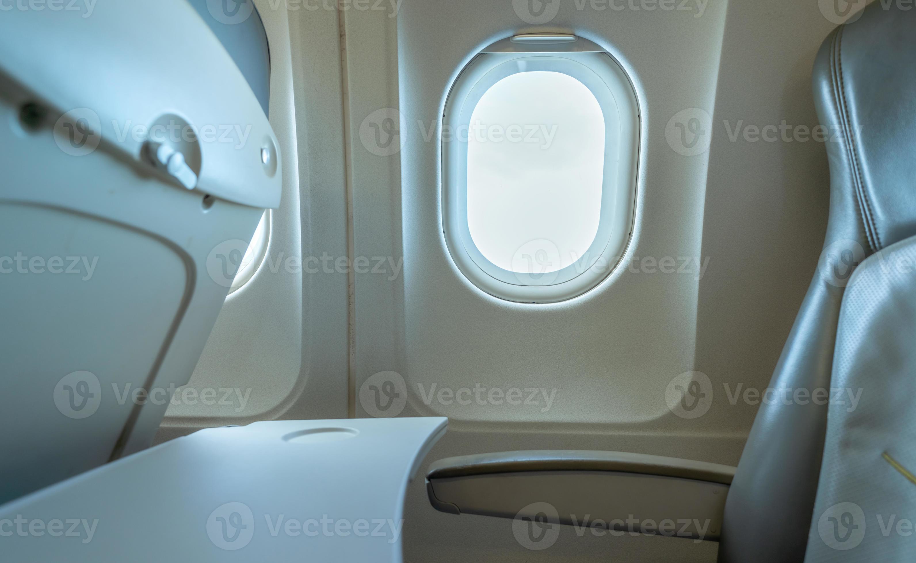 Plane window with white sunlight. Empty plastic airplane tray table at